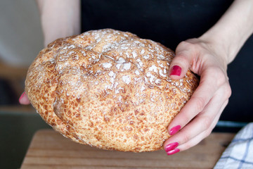 Woman hands hold freshly baked bread, closeup