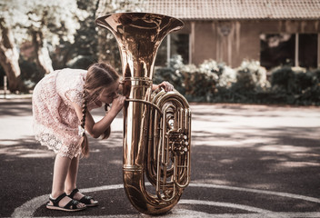 Mädchen probiert Tuba zu spielen - obrazy, fototapety, plakaty