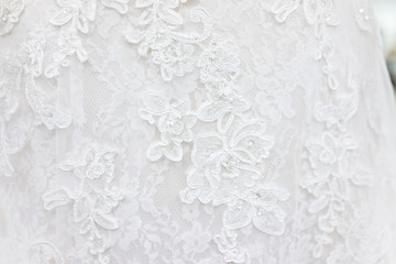 Macro closeup of lace wedding dress veil material, white garment textile with shiny rhinestones...