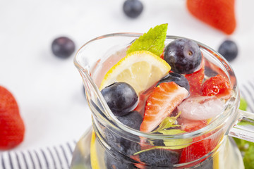 Herbs and fruits flavored infused water. Summer refreshing drink. Health care, fitness, healthy nutrition diet concept.