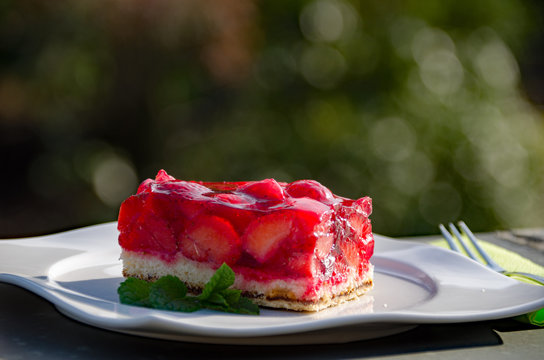 Erdbeerschnitte mit frischen Erdbeeren auf weissem Teller