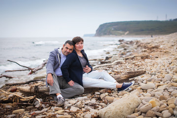 Beautiful couple on the beach at sunset and wearing casual clothes