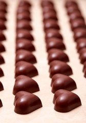 Obraz na płótnie Canvas Heart-shaped chocolates arranged in rows