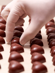Heart-shaped chocolates being ordered by a gloved hand