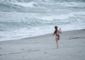 Fototapeta premium unknown woman stops to take a picture of the massive waves