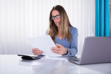 Businesswoman Reading Document In Office