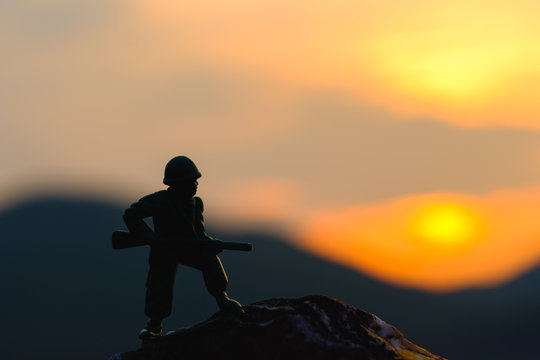 Army hold gun on mountains silhouette