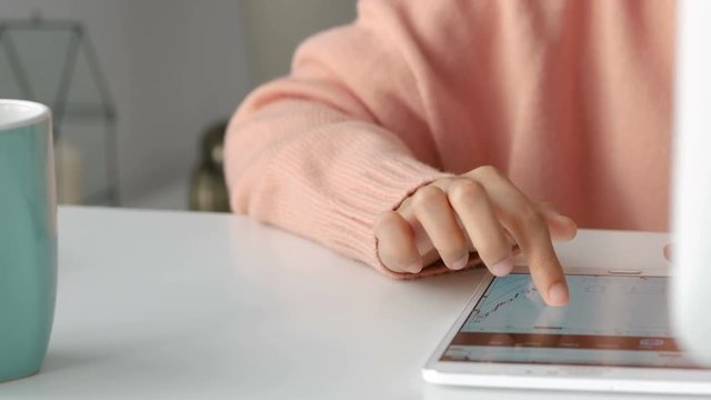 Close up Young asian women business owners using app smartphone and play the stock maket in office.