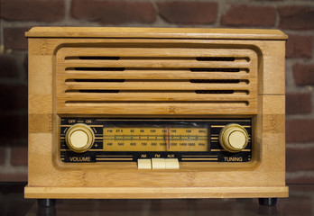 Antique; retro wooden radio on red stone wall background