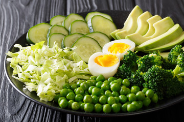 Healthy green food: fresh vegetables avocado, peas, cabbage, cucumber, broccoli and boiled eggs close-up. horizontal