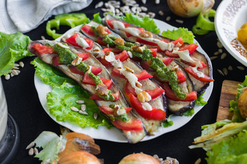 Roasted baked eggplants slices with tomatoes, walnuts dressing, salad leaves and vegan sunflower seeds mayonnaise. Raw vegan vegetarian healthy food. Vegan lunch or dinner