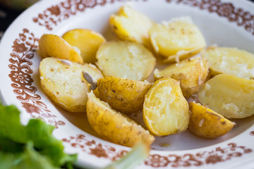 Baked , steamed new potato halves with spices, rock salt and olive or sunflower seeds oil. Raw vegan vegetarian healthy food for lunch or dinner. Organic farm product