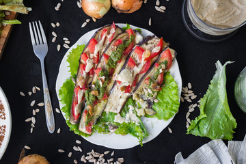 Roasted baked eggplants slices with tomatoes, walnuts dressing, salad leaves and vegan sunflower seeds mayonnaise. Raw vegan vegetarian healthy food. Vegan lunch or dinner