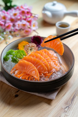 Salmon sashimi slice fresh serve on ice with tea, Japanese style