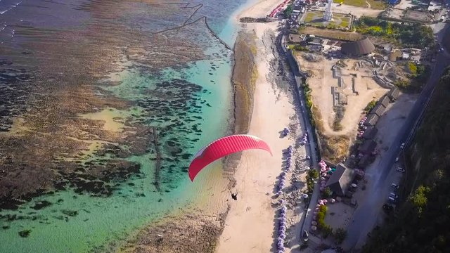 Red hang-glider floats over the ocean Freedom Beautiful view Bali holidays