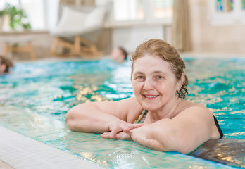 happy senior woman in the pool. Space for text