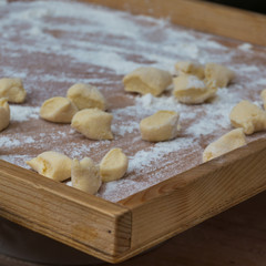 Fototapeta na wymiar Small Dumplings on Wooden Board with Flour: Italian Gnocchi Pasta
