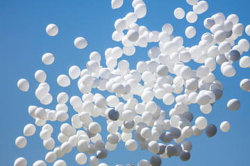 White balls flying in the blue sky