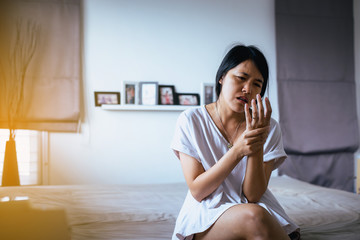 Woman having a neck her hand,Female feeling exhausted and painful on bedroom