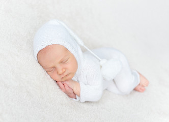 Infant boy in white bodysuit