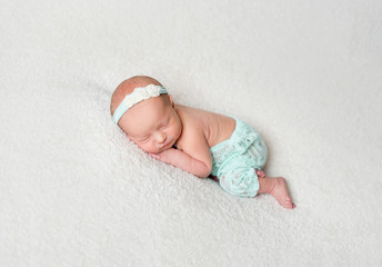 Sweet newborn girl hugging her toy while sleeping