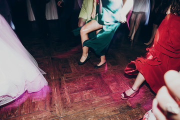 happy dancing at wedding reception. gorgeous guests and wedding couple having fun and partying in...