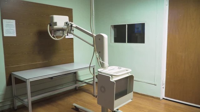 Medical office with X-ray equipment. X-ray room in a hospital ER operating room with a classic ceiling-mounted x-ray system. Modern medical equipment, interventional medicine and healthcare concept.