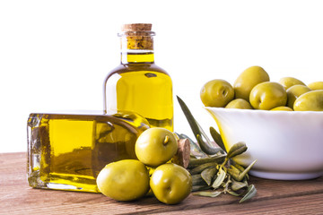 bowl of olives and bottle of extra virgin oil on white background