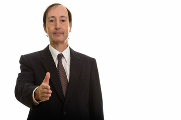 Studio shot of mature businessman giving handshake