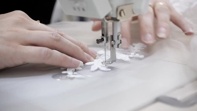 close-up of sewing machine, stitch thread seam. Equipment for sewing elegant wedding dress. Hand made