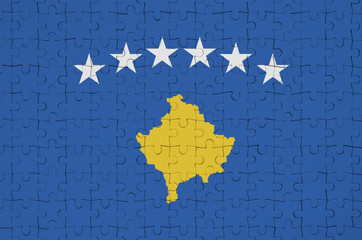 Kosovo flag  is depicted on a folded puzzle