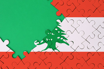 Lebanon flag  is depicted on a completed jigsaw puzzle with free green copy space on the left side
