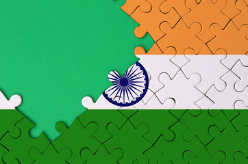 India flag  is depicted on a completed jigsaw puzzle with free green copy space on the left side