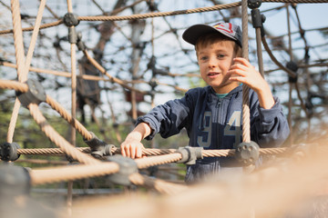 A 5-year-old boy climbs on the ropes at the playground