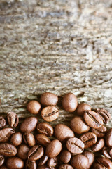 Roasted coffee beans on rustic wooden background. Food ingredients, top view, space for text