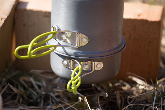 A closeup of a boiling pot on a gas primus cooking dinner for hikers. Outdoors kitchen.