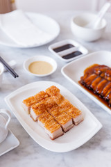 Golden Crispy Pork Belly cut in cube served with mustard sauce and hot tea with chopsticks.