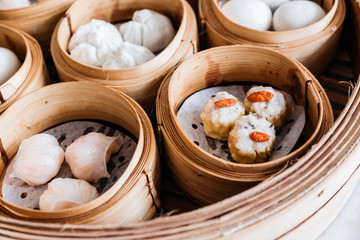 Shumai topping with goji berry served in steamer baskets with many kind of Dim sum.