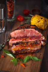 Rare cooked meat with herbs on a wooden board