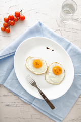 Two fried eggs on a white plate