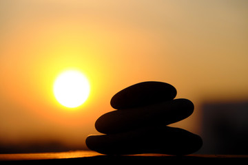 stack of pebble on yellow sun background