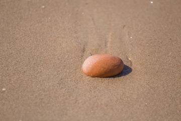 Beautiful smooth sea stones in the sands of the beach. Closeup photo of stone textures and shapes.