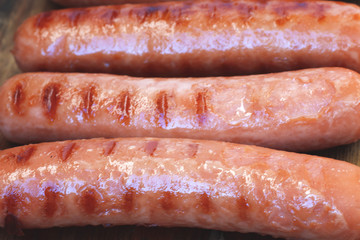 Grilled sausages close-up located on a wooden surface