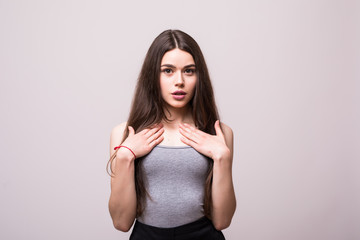 Portrait of offended and angry wealthy woman, pointing at her with both hands and lifting eyebrows in disagreement, standing over gray background. Girl got promotion but coworker thinks it is unfair