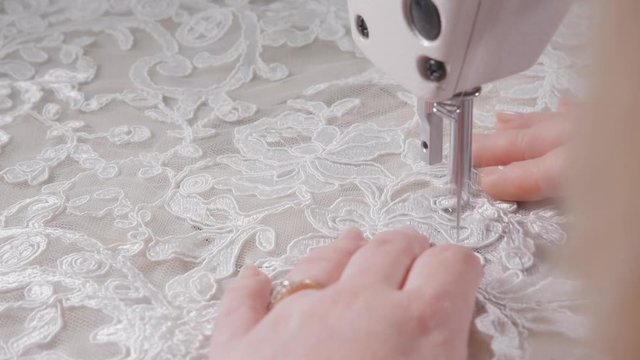 close-up of sewing machine, stitch thread seam. Equipment for sewing elegant wedding dress. Hand made