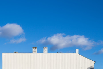 White side of a house and a blue sky with clouds
