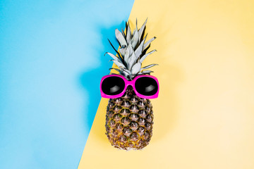 Fashion Pineapple. Summer Color. Tropical Fruit with Sunglasses. Minimalist style. Creative Art concept. Pineapple on pink, yellow and blue pastel colors.