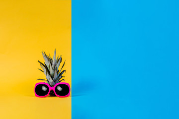 Fashion Pineapple. Summer Color. Tropical Fruit with Sunglasses. Minimalist style. Creative Art concept. Pineapple on pink, yellow and blue pastel colors.