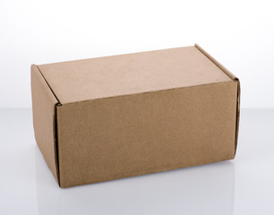 A small cardboard box on a white table. Free space on the surface