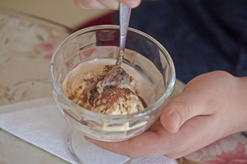 dessert from a creamy ice cream creme brulee in a glass cup in hands